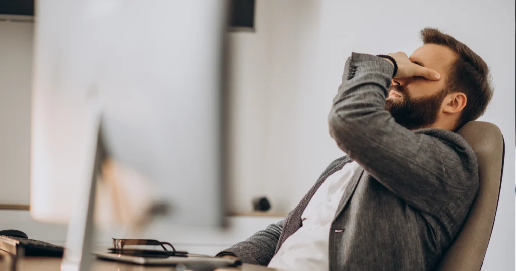 Homem demonstrando cansaço excessivo no ambiente de trabalho